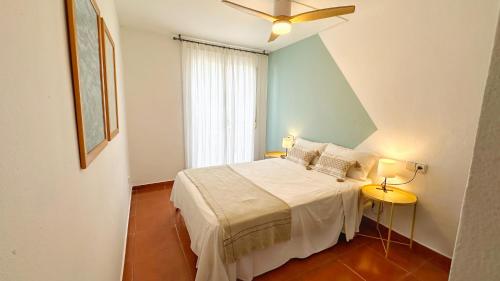 une chambre avec un lit et un ventilateur de plafond dans l'établissement Nomad Haux in the heart of Tossa 2, à Tossa de Mar