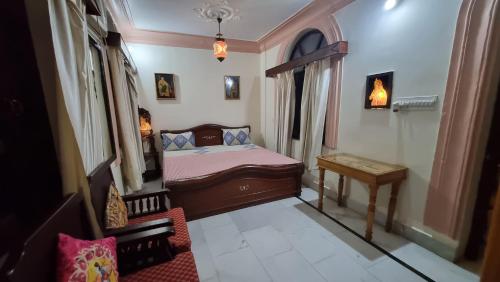 a small bedroom with a bed and a table at Kanhaia Haveli in Pushkar