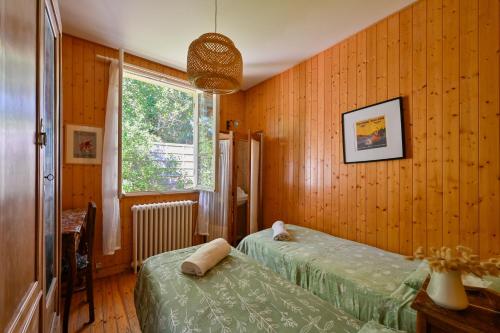 a bedroom with two beds and a window at Petit Colibri - Proche de la plage in La Baule
