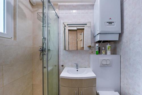 a small bathroom with a sink and a shower at Petit Colibri - Proche de la plage in La Baule