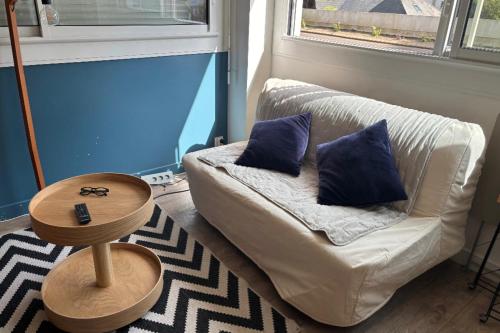 - un salon avec un canapé blanc et 2 oreillers bleus dans l'établissement Charming T1 on the seafront, à La Baule