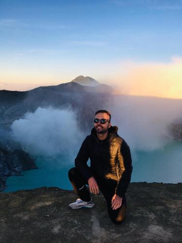 a man sitting on the edge of a mountain at Nio Homestay and Tour in Licin