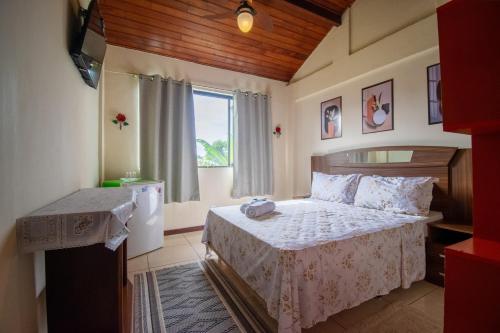 ein Schlafzimmer mit einem Bett und einem Fenster in der Unterkunft Flats Tartaruga Búzios in Búzios