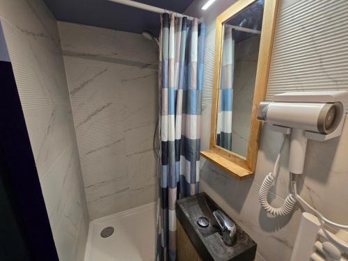 Un baño con ducha con lavabo y espejo. en 1D- Studio tout équipé 10mins de Paris Expo porte de Versailles, en Issy-les-Moulineaux