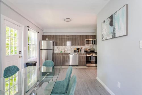 a kitchen with a glass table and green chairs at Modern House in Black Rock in Bridgeport
