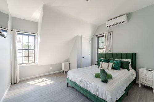 a bedroom with a green and white bed with green pillows at Modern House in Black Rock in Bridgeport