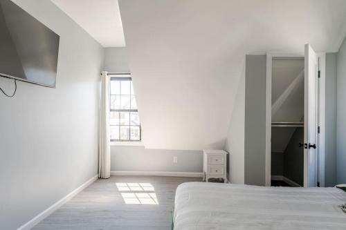 a white bedroom with a bed and a window at Modern House in Black Rock in Bridgeport