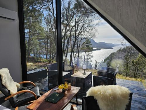 a room with a table and chairs and a large window at NorGlamp Glamping in Hjelmeland