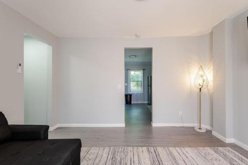 a living room with white walls and a black couch at Modern House in Black Rock in Bridgeport