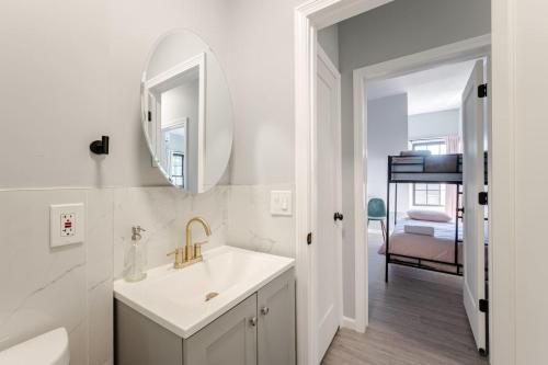a white bathroom with a sink and a mirror at Modern House in Black Rock in Bridgeport