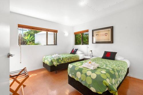 a bedroom with two beds and a window at HORIZON SURF LODGE plus private spa in Raglan