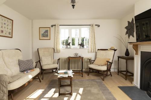 a living room with a couch and chairs and a fireplace at Historic Farmhouse Retreat Foot of the South Downs in Wivelsfield
