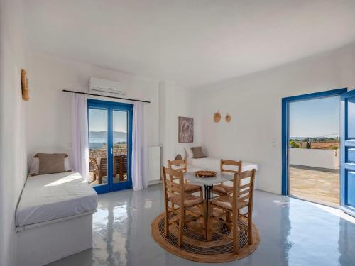 a room with a bed and a table and chairs at Villa Bianca - Sunset and beach access in Kampos Paros