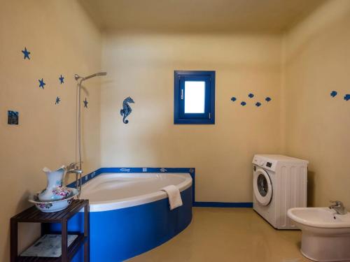 a bathroom with a blue tub and a sink at Villa Bianca - Sunset and beach access in Kampos Paros