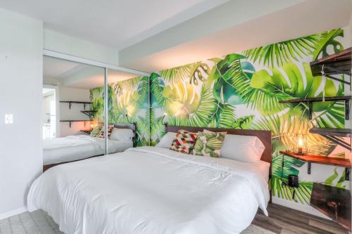 a bedroom with two beds and a mural of leaves at Chic 1BR plus Den Condo with Fast WiFi and Free Parking in Toronto