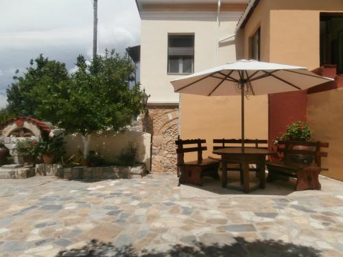a patio with a table and an umbrella at Christina Guest House in Mystras