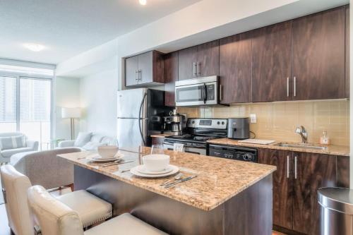 a kitchen with wooden cabinets and a counter top at 1BR plus Den Condo with Balcony in Heart of Toronto in Toronto