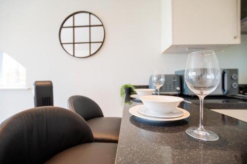 a kitchen with a table with two wine glasses on it at Cozy property in Ealing