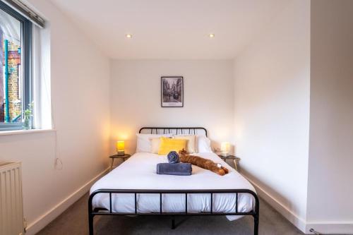 a bedroom with a bed with two lamps on it at Cozy property in Ealing