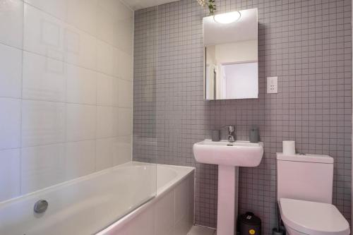 a white bathroom with a sink and a toilet at Cozy property in Ealing
