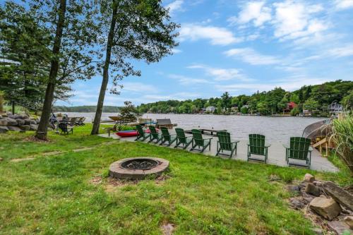 a group of chairs and a fire pit next to a lake at beautiful lakefront lodge in Lake Harmony