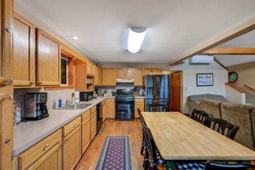 a kitchen with wooden cabinets and a wooden table at beautiful lakefront lodge in Lake Harmony