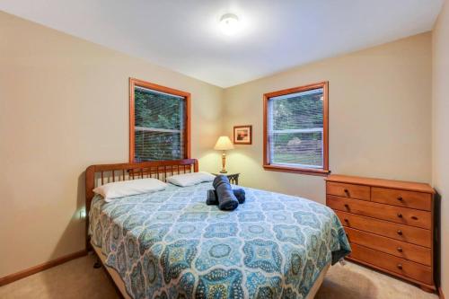 a bedroom with a bed and a dresser and two windows at beautiful lakefront lodge in Lake Harmony