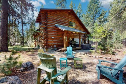 a log cabin with rocking chairs in front of it at Sunriver Log Cabin in Bend