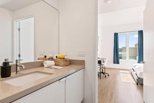 a white kitchen with a sink and a table at Little Tokyo Gem, Steps from Shops with Free Parking in Los Angeles