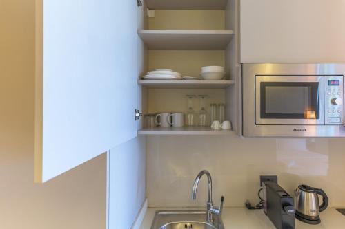 a kitchen with a sink and a microwave at Jounieh Living - Residences by Local Host in Ed Dkârîne