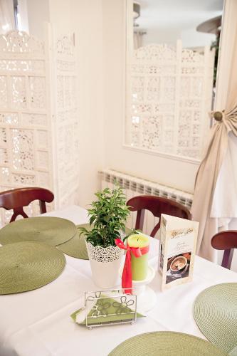 a table with green chairs and a plant on it at Oberża Złota Gęś in Siewierz