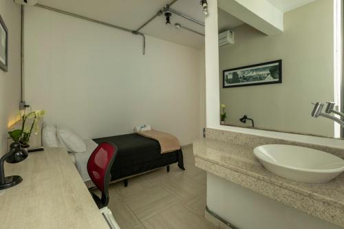 Un baño con un lavabo y una cama dentro. en Hotel 4 Living, en São Paulo