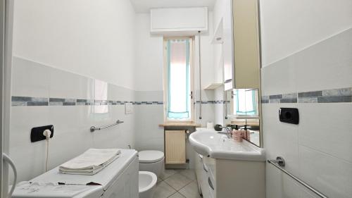 een witte badkamer met een wastafel en een toilet bij Hostdomus - La casina di Monica in Loano