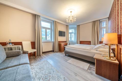 a hotel room with a bed and a couch at Hotel Neue Post I self check-in in Innsbruck