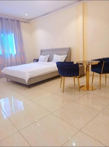 um quarto com uma cama, uma mesa e cadeiras em Bel'hôtel à 5mn de l'aéroport em Bangui