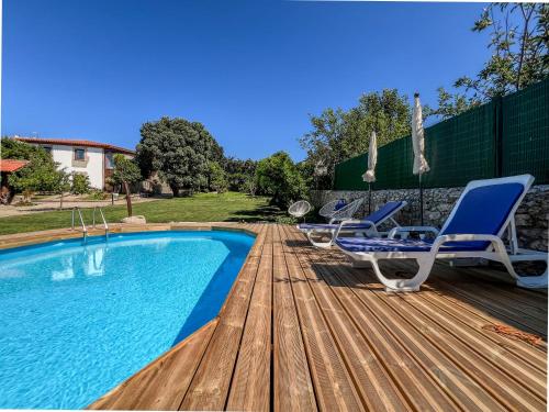 una terraza de madera con sillas y una piscina en Casa de Perre, en Viana do Castelo