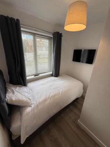 ein kleines Schlafzimmer mit einem Bett und einem Fenster in der Unterkunft 3 Bed Home From Home Contractor & Family Stay DY5 in Woodside