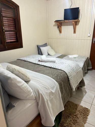 two beds sitting next to each other in a room at pousada vó biloca in Urubici
