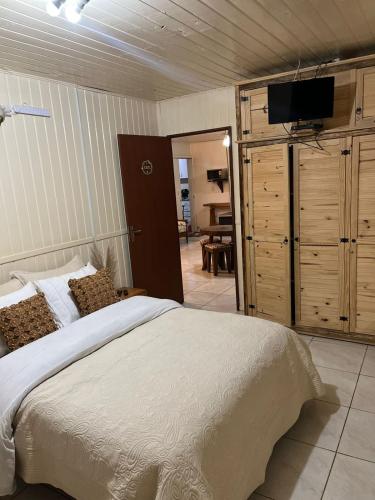 a bedroom with a bed and a flat screen tv at pousada vó biloca in Urubici