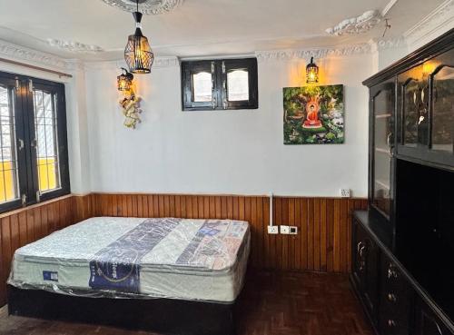 une chambre avec un lit et une télévision dans l'établissement TheNest Heritage Villa Near Pashupati- Luxury Stay in Kathmandu, à Katmandou