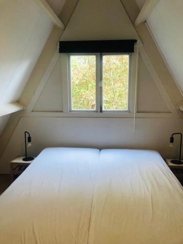 a white bed in a room with a window at Villa Pimpelmees - Sunclass 54 in Durbuy