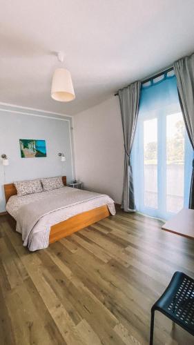 a bedroom with a bed and a large window at CASA MONTEFINESE in Casamassima