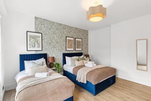 two beds in a room with white walls at Pimlico gem Central London next the London Eye in London