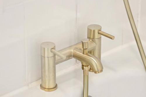 a brass faucet in a bathroom with a sink at Pimlico gem Central London next the London Eye in London