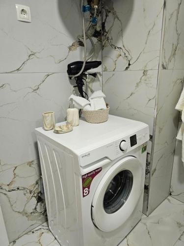 a washing machine in a bathroom with a mirror at Besa Apartment in Ferizaj