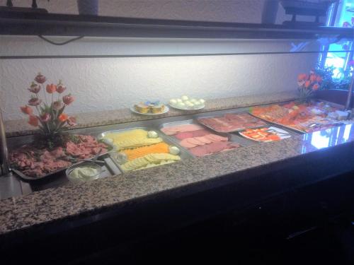a refrigerator filled with different types of food on a counter at Hotel-Restaurant Cafe Caro in Carolinensiel