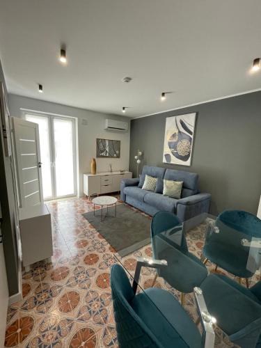 a living room with a blue couch and chairs at Vento di Sicilia in Carini