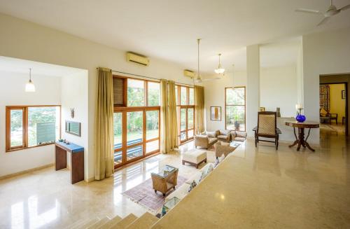 a large living room with a couch and a table at 3BR Villa w Pvt Pool and River View in Anjuna