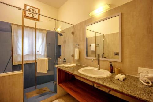 a bathroom with a sink and a large mirror at 3BR Villa w Pvt Pool and River View in Anjuna