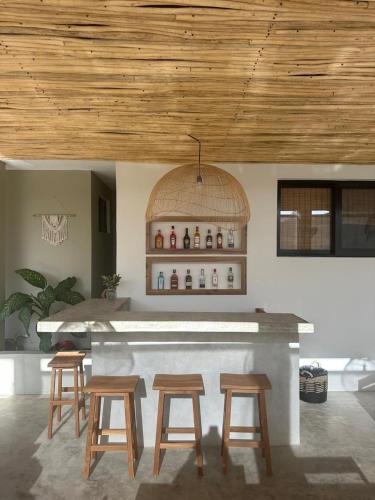 a bar with four wooden stools in a room at Kaia Beach Lodge en Cosón in Las Terrenas